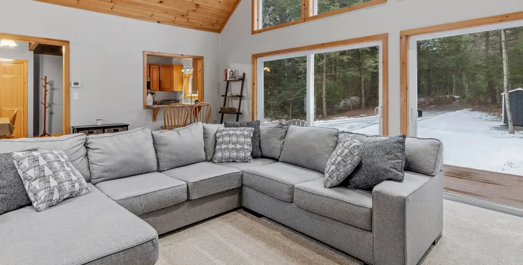 Nice sectional in the living room in front of big windows showing the snow outside