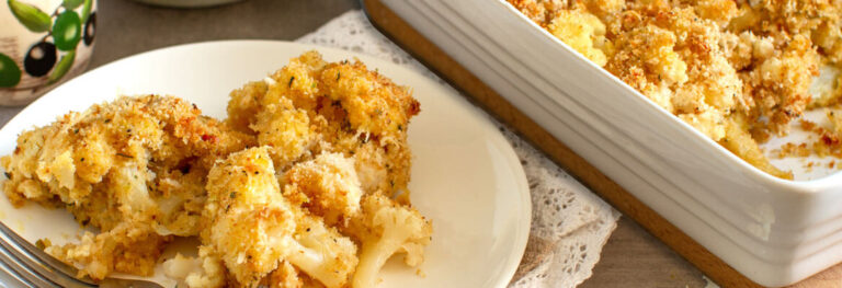 Crispy Golden cauliflower on a white plate with a dish full beside the plate.