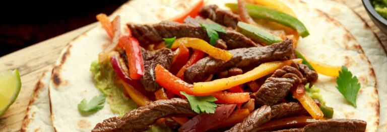 strips of peppers, steak onions on a tortilla