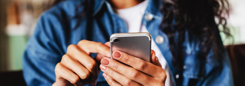 female hands typing onto a cell phone