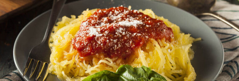 Spaghetti Squash with a nice red Marinara in a grey bowl with a fork on the side