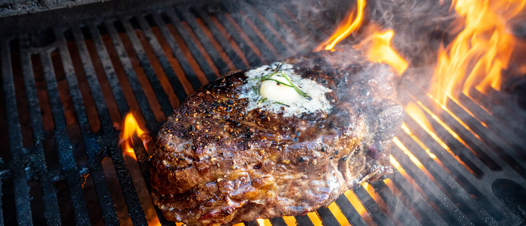 juicy steak grilling on a steak