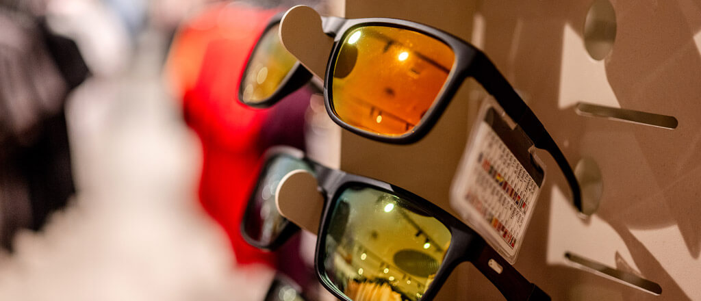 sunglasses with orange tinted glass on a wall rack