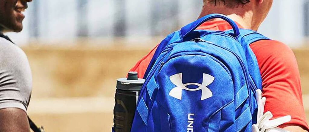 male walking away carrying a Under Armour backpack
