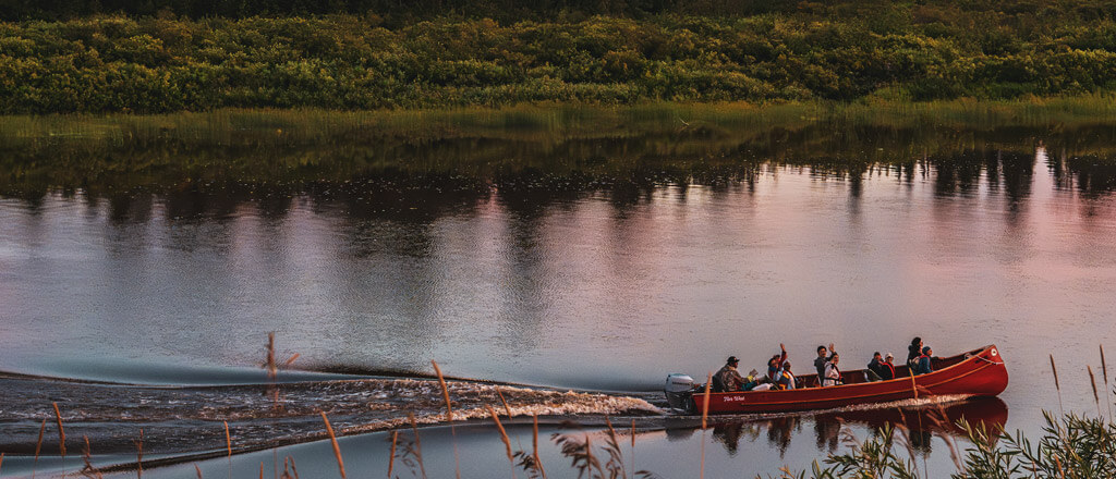 canoeing on a lake surrounded by forests during a sunset