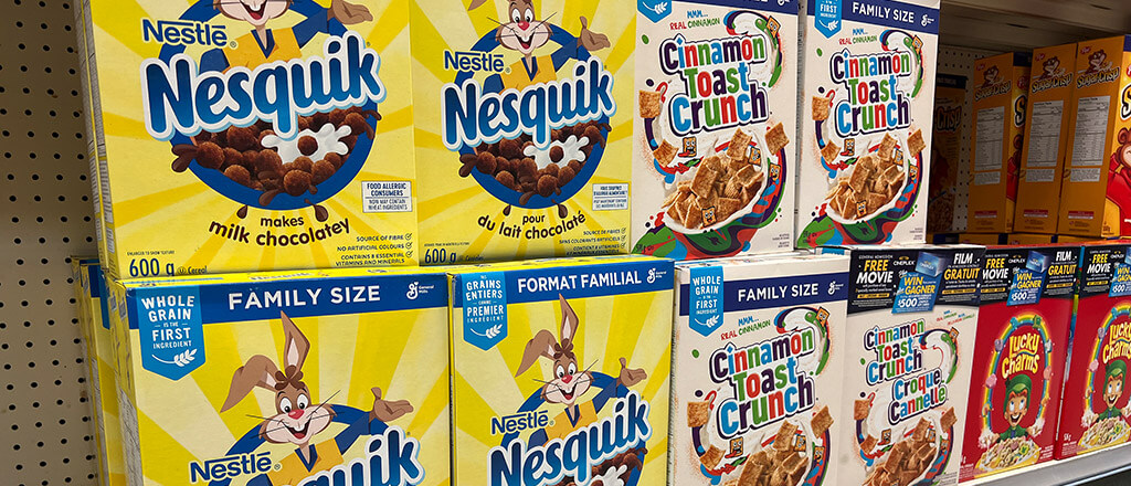 Boxes of breakfast cereal lined up on shelves.